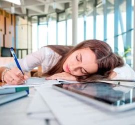 Frau schläft auf Schreibtisch
