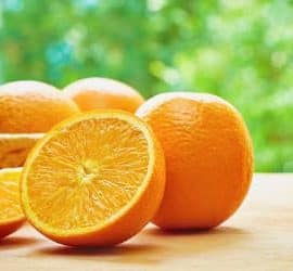 Orangen auf dem Tisch vor einem Baum.