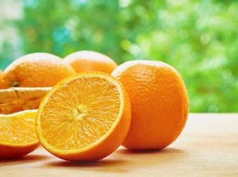 Orangen auf dem Tisch vor einem Baum.