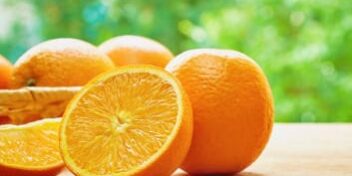 Orangen auf dem Tisch vor einem Baum.