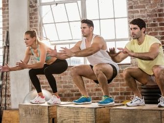 3 Sportler machen Jumping Squats