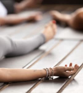 Frau liegt entspannt auf einer Yogamatte