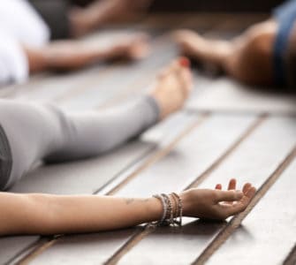 Frau liegt entspannt auf einer Yogamatte