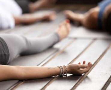 Frau liegt entspannt auf einer Yogamatte