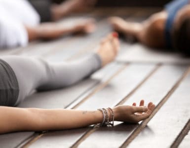 Frau liegt entspannt auf einer Yogamatte