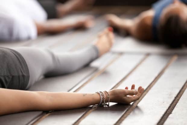 Frau liegt entspannt auf einer Yogamatte