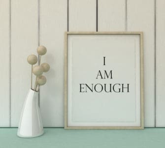 Weißes Bild mit hellem Rahmen darin steht der Schriftzug I AM ENOUGH