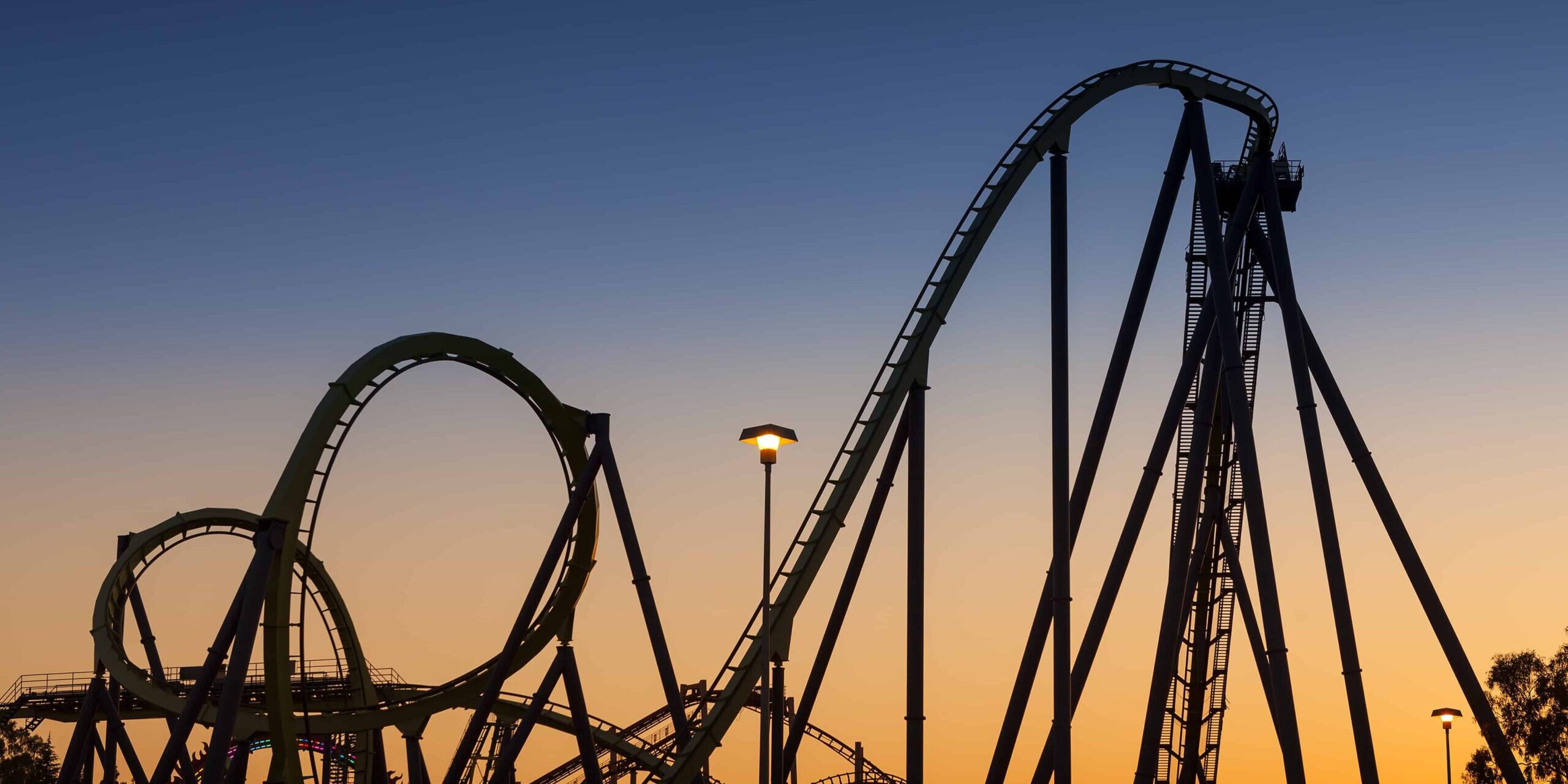 Stimmungsschwankungen Eine Achterbahn vor einem Sonnenuntergang