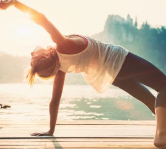 Junge Frau macht Yoga am See und fühlt sich wohl