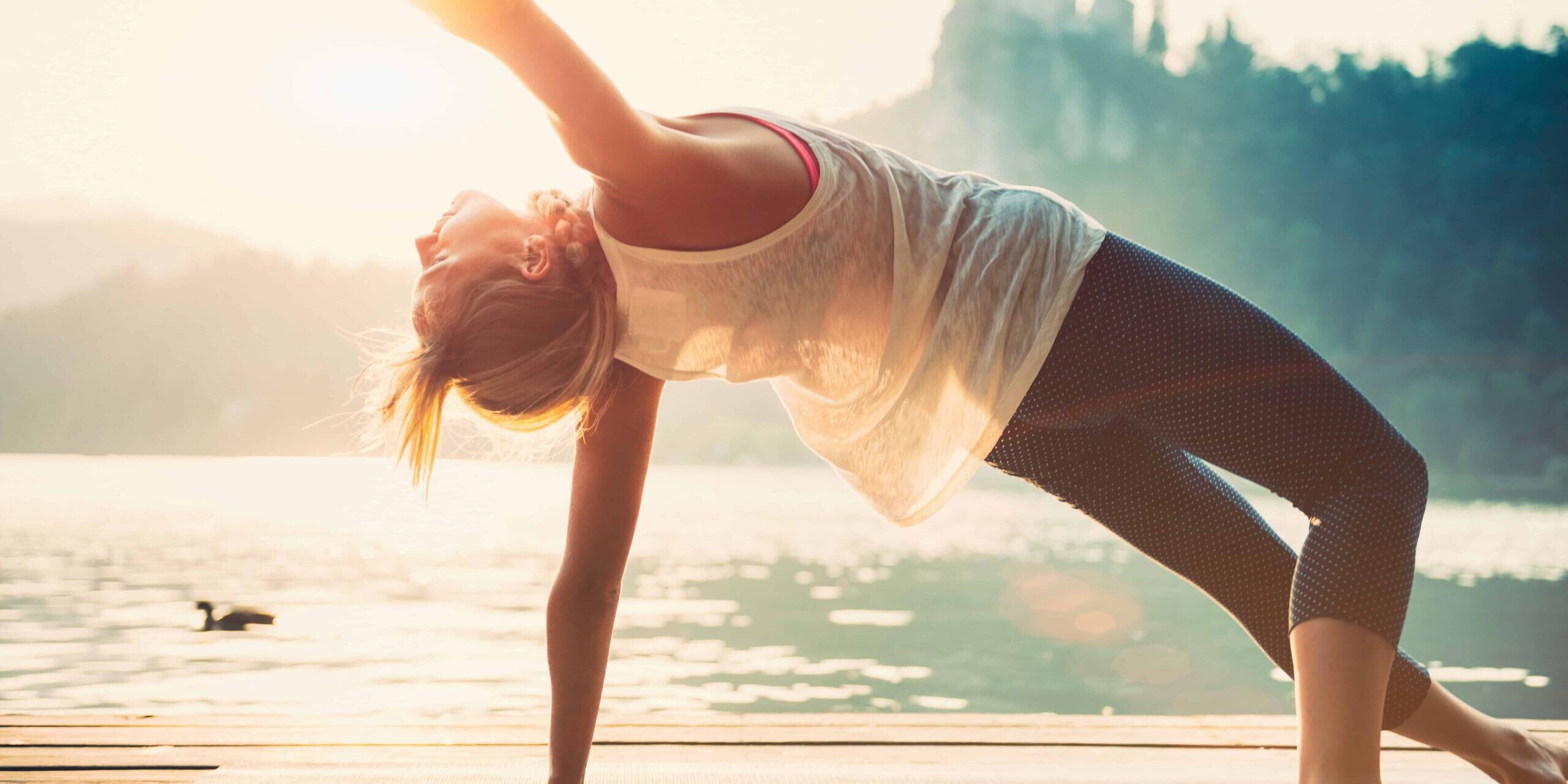 Körpergefühl Junge Frau macht Yoga am See und fühlt sich wohl