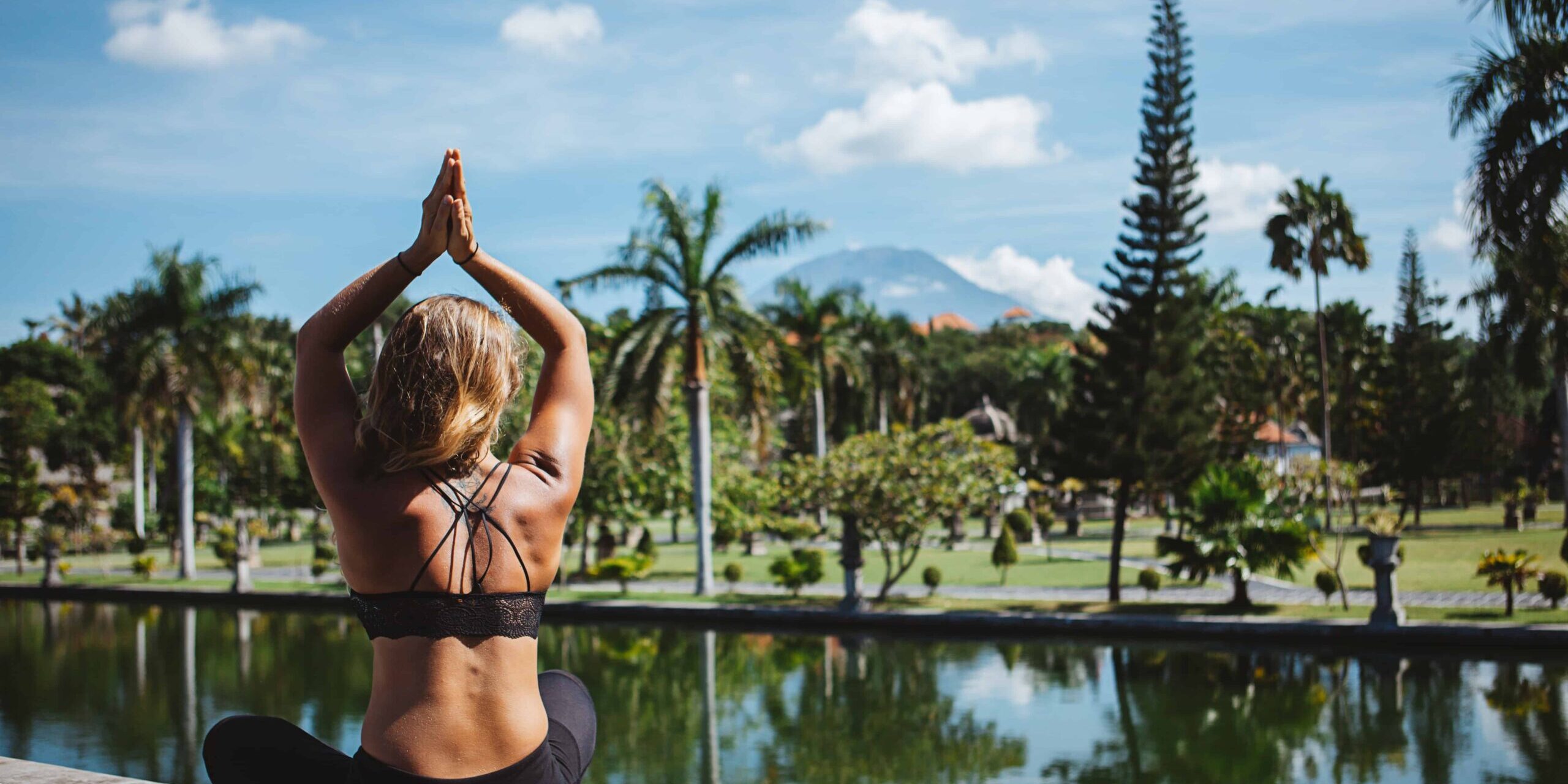Yoga auf Bali Junge Frau sitzt im Lotussitz und macht Yoga auf bali