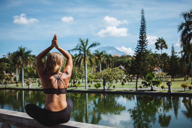 Yoga auf Bali Junge Frau sitzt im Lotussitz und macht Yoga auf bali