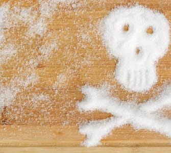 Holztisch mit Fructose Pulver in Totenkopf Form - gefährlicher Dickmacher