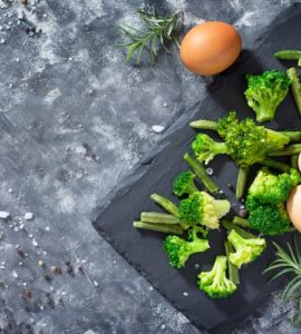 broccoli und eier auf brett dunkelgrauer tisch