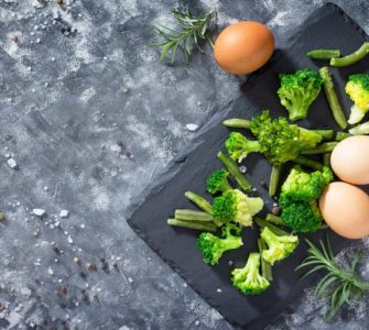 broccoli und eier auf brett dunkelgrauer tisch