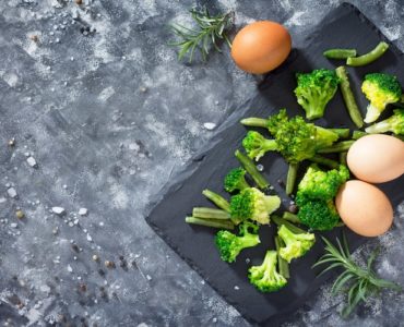 broccoli und eier auf brett dunkelgrauer tisch