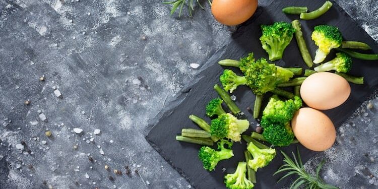 broccoli und eier auf brett dunkelgrauer tisch