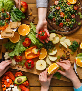 Tisch gedeckt mit Tellern voller gesunder, vegetarischer und veganer Lebensmitteln