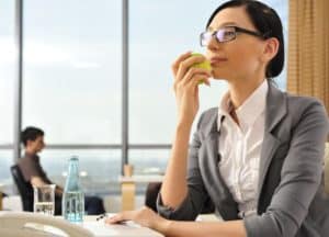 Frau isst gesund am Arbeitsplatz