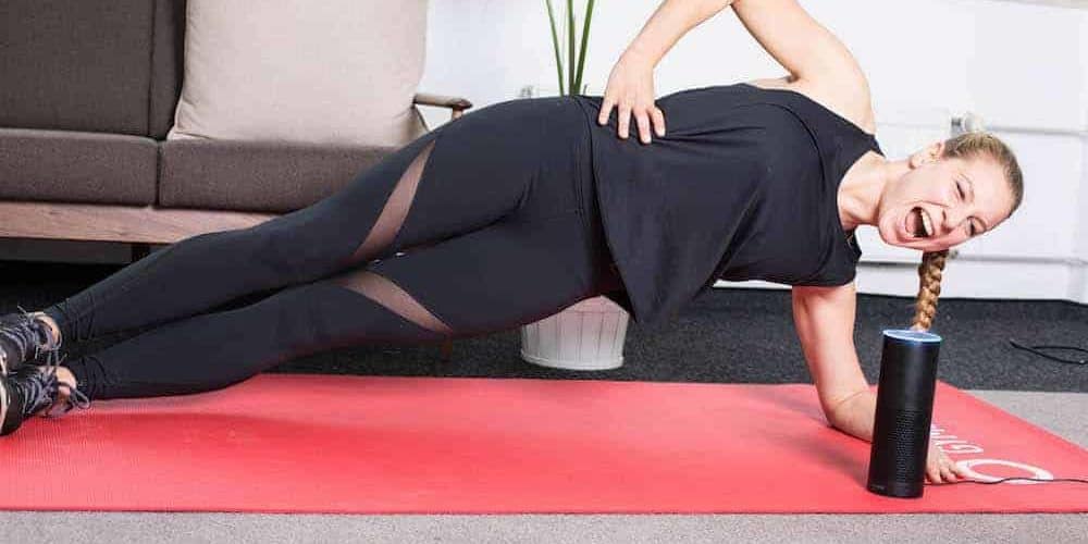 Gymondo Alexa Skill Junge Frau trainiert auf roter Trainingsmatte mit dem GYMONDO Alexa Skill