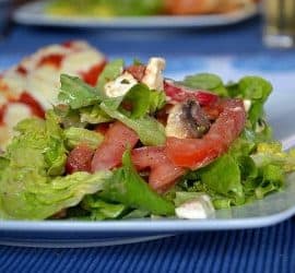 Grüner Sommersalat mit Tomaten, Feta und Pilzen an einem Mango-Pfirsich-Dressing