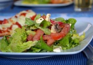 Grüner Sommersalat mit Tomaten, Feta und Pilzen an einem Mango-Pfirsich-Dressing