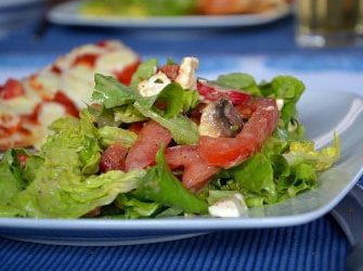 Grüner Sommersalat mit Tomaten, Feta und Pilzen an einem Mango-Pfirsich-Dressing