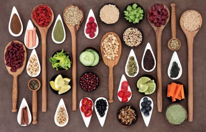 Superfoods-Gewürze, -körner, -beeren und -samen auf Löffeln und in Keramikschalen portioniert