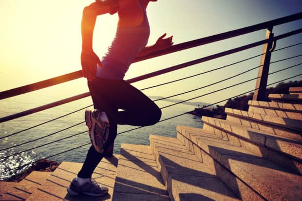 Frau in Sportkleidung rennt Treppe hoch