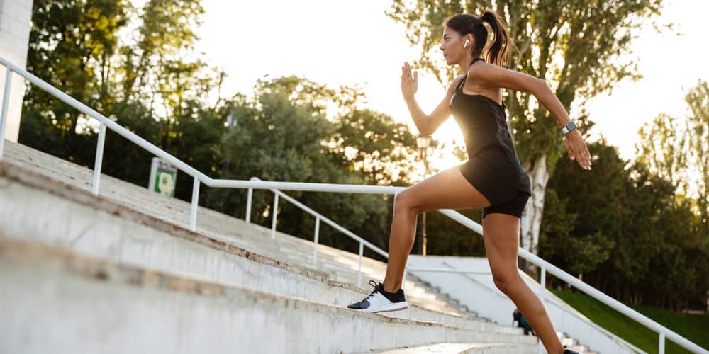 Fettkiller Treppensteigen Junge sportliche Frau rennt eine Treppe hoch