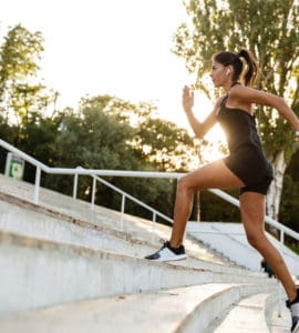 Junge sportliche Frau rennt eine Treppe hoch