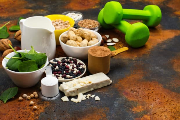 Vegane Lebensmittel und Kurzhanteln auf Tisch