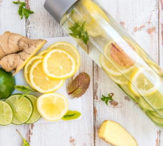 Eine Glasflasche mit frischem Ingwerwasser und Zitronenscheiben