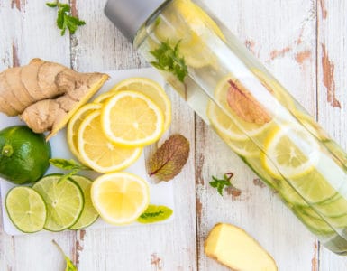 Eine Glasflasche mit frischem Ingwerwasser und Zitronenscheiben