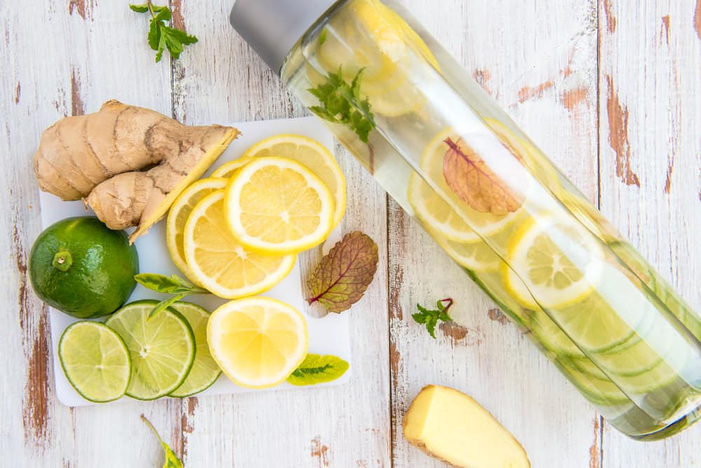 Eine Glasflasche mit frischem Ingwerwasser und Zitronenscheiben