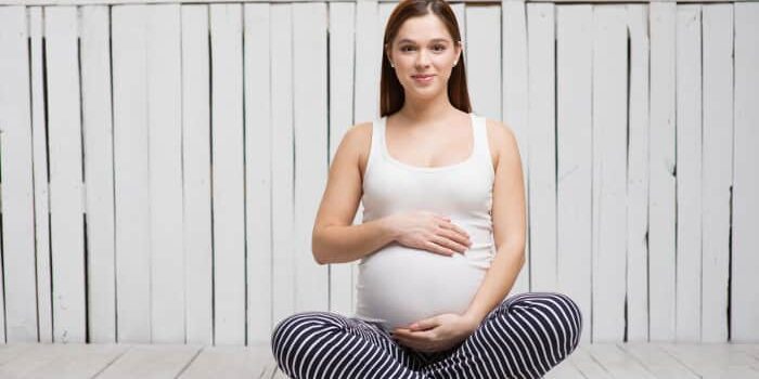 yoga schwangerschaft schwangere frau lotussitz Schwangere Frau im Lotussitz.