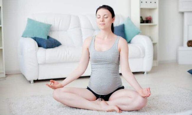 yoga übung schwangere frau im wohnzimmer