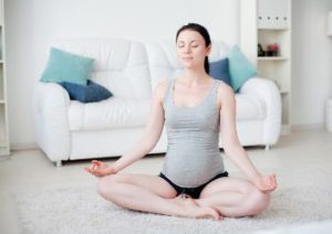 yoga übung lotussitz schwangere frau.