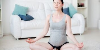 yoga übung lotussitz schwangere frau.