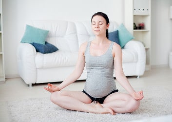 yoga übung lotussitz schwangere frau.