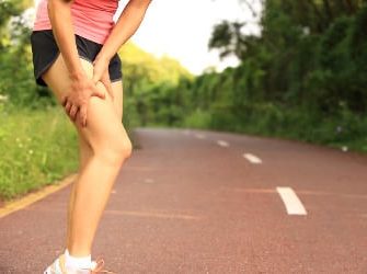 Übersäuerte Sportlerin hält sich den Oberschenkel